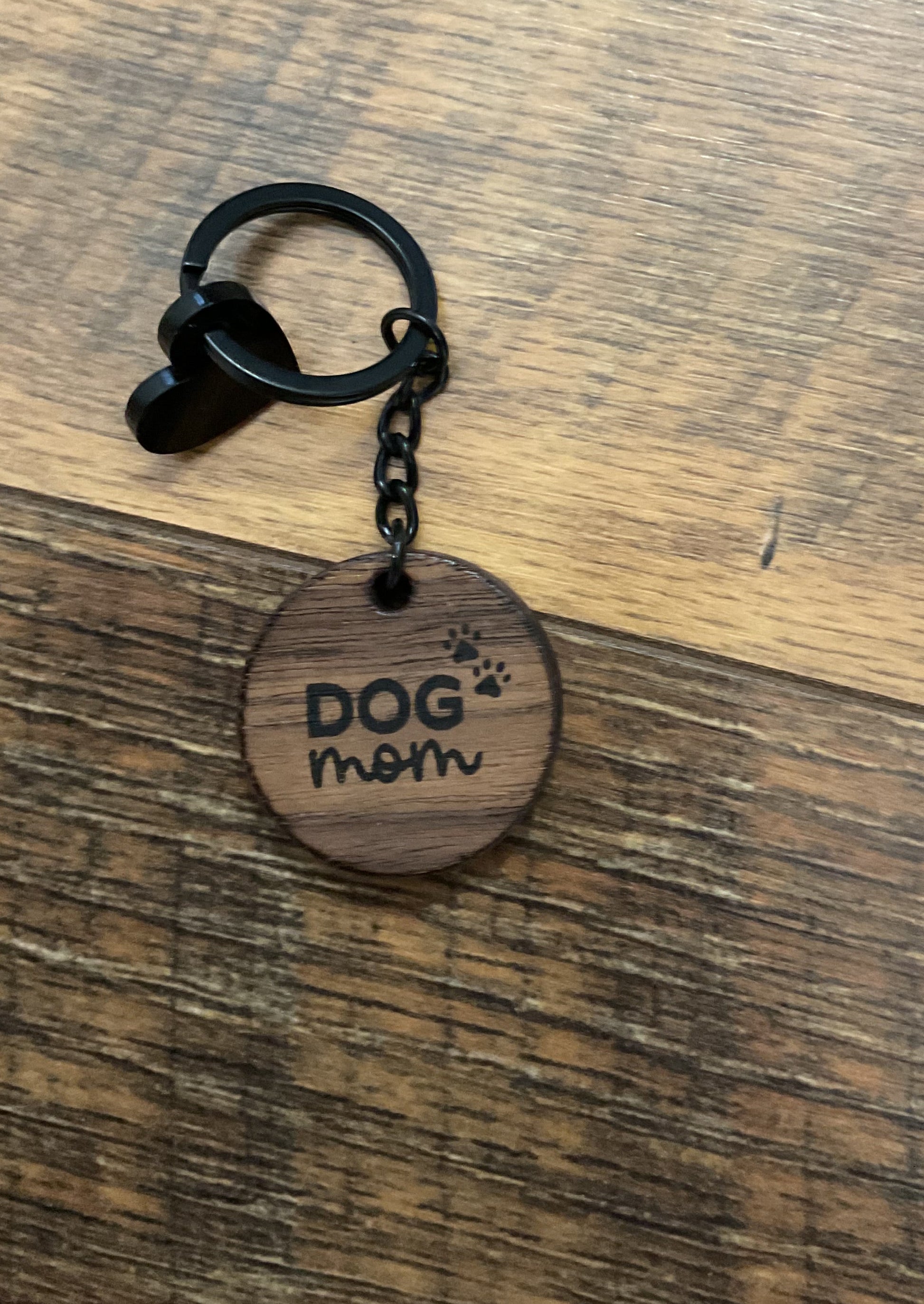 Wooden keychain with engraved text on a wooden surface