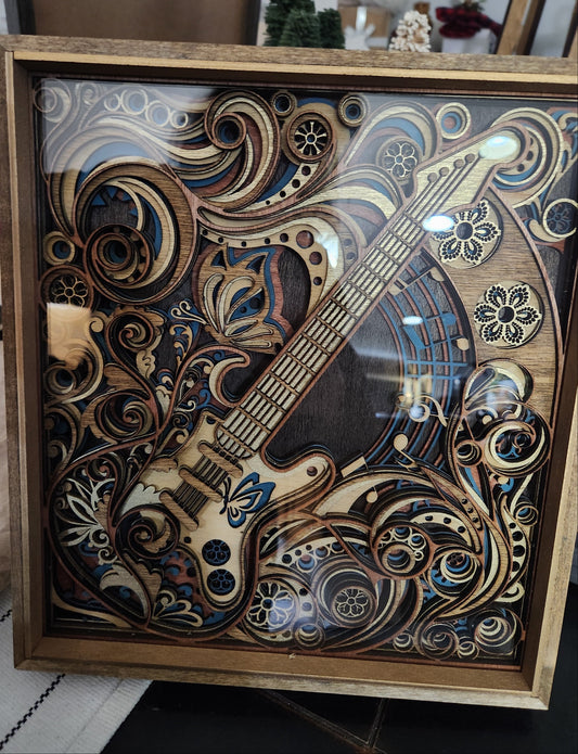 Wooden guitar model with intricate designs in a decorative frame